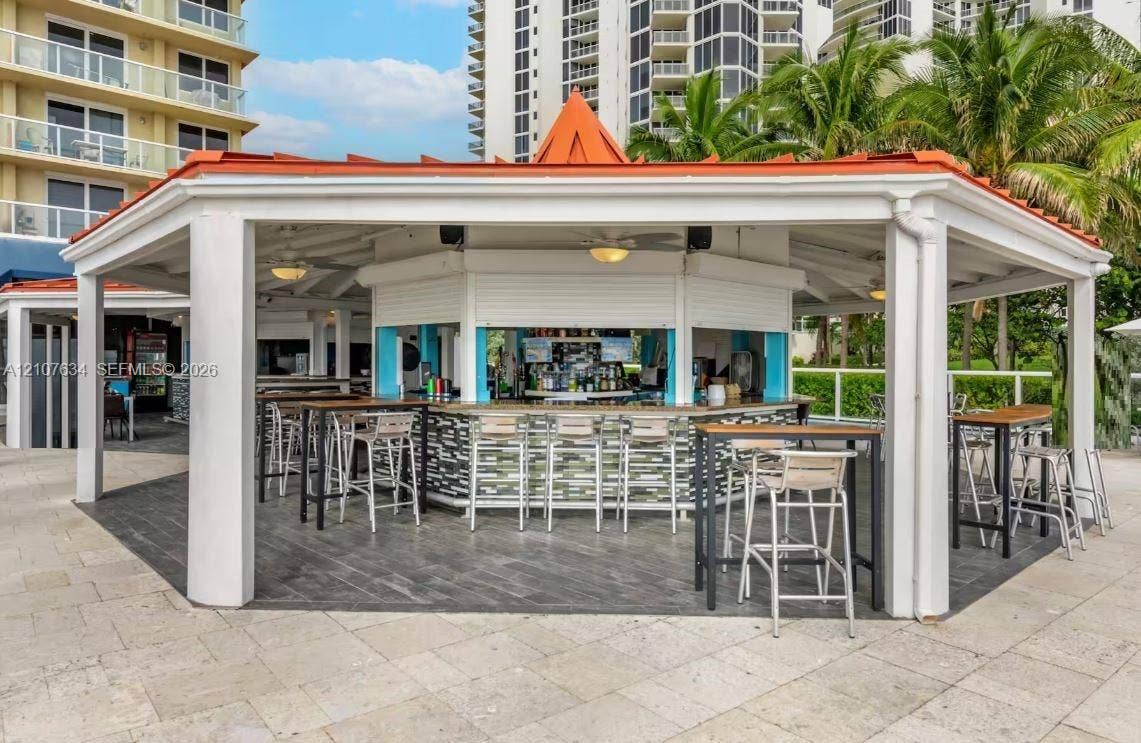 19201 Collins Avenue, #941, Sunny Isles Beach, FL 33160 Covered outdoor pavilion featuring a built-in bar, tiled flooring, metal-roofed structure with supporting columns, and recessed lighting