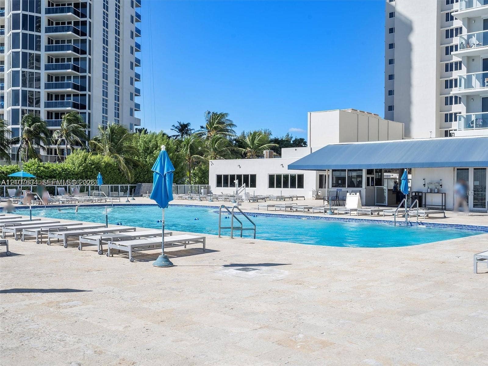 19201 Collins Avenue, #941, Sunny Isles Beach, FL 33160 Resort-style swimming pool featuring a tiled finish, expansive stone-paved deck, and a shaded outdoor pavilion