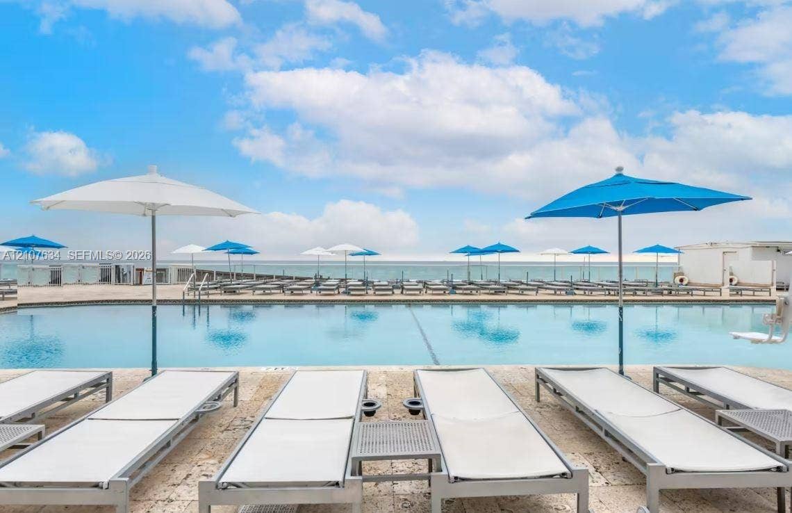 19201 Collins Avenue, #941, Sunny Isles Beach, FL 33160 Outdoor swimming pool featuring stone-paved decking and a glass-paneled perimeter railing