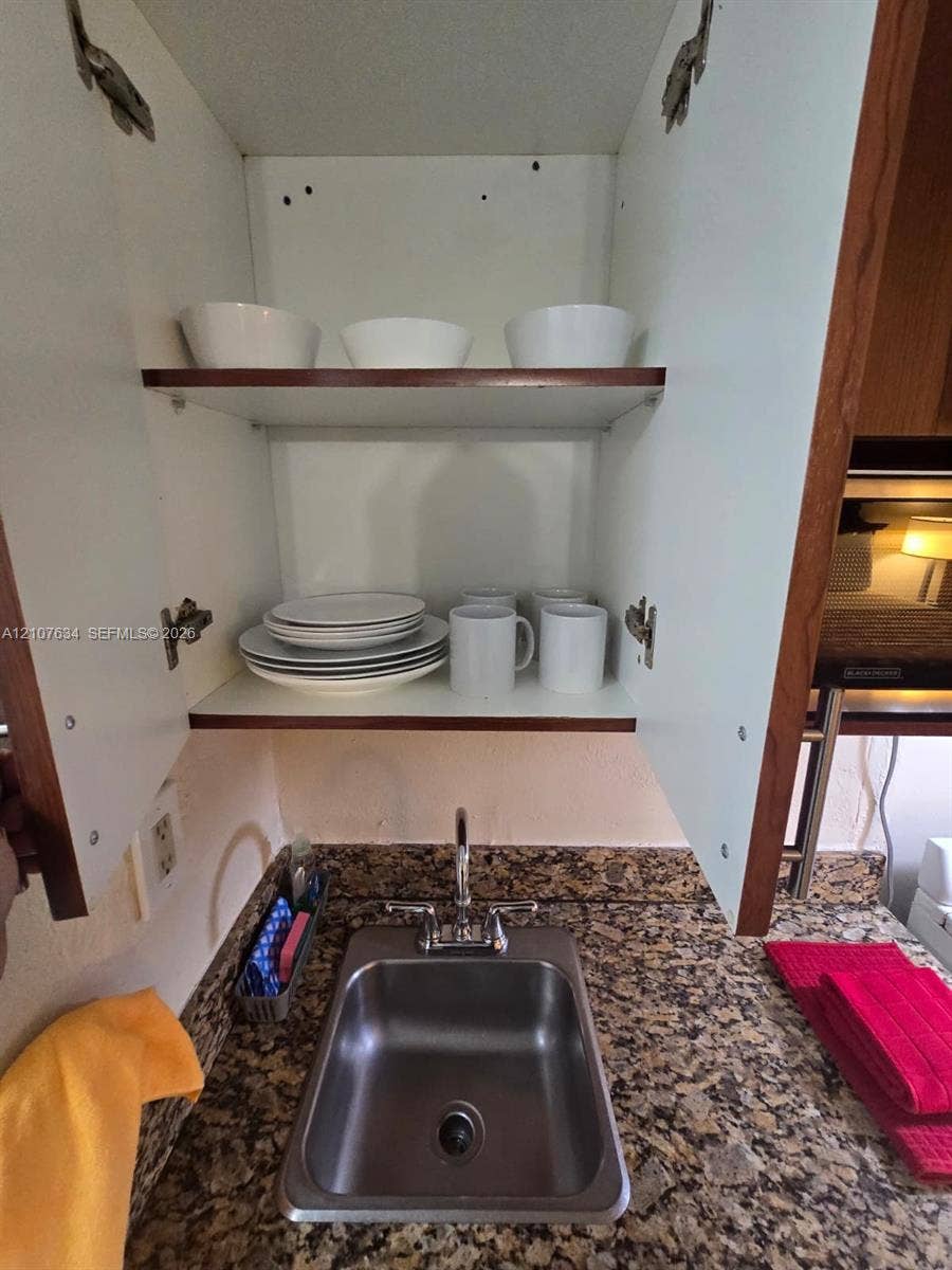19201 Collins Avenue, #941, Sunny Isles Beach, FL 33160 Built-in cabinetry with adjustable shelving, stone-surfaced countertop, and stainless steel drop-in sink with dual-handle faucet