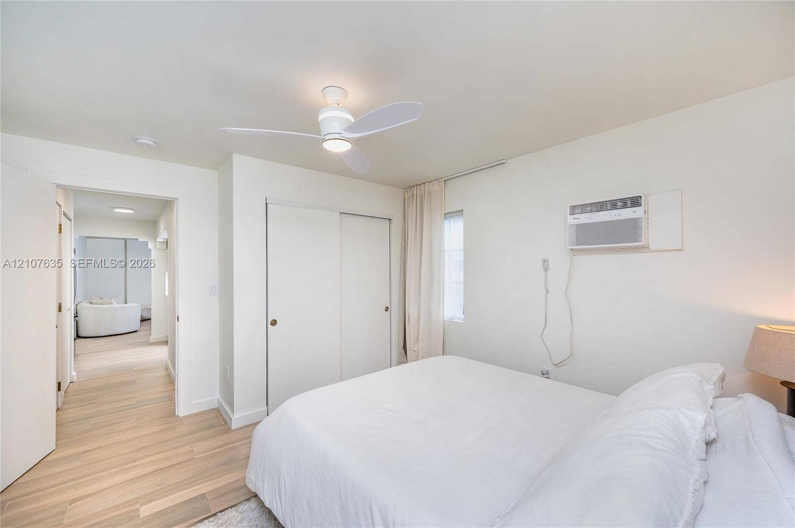 217 Madeira Avenue, #3, Coral Gables, Coral Gables, FL 33134 Room featuring wood-finish flooring, a ceiling fan with integrated lighting, a sliding-door closet, and an installed window-mounted air conditioning unit