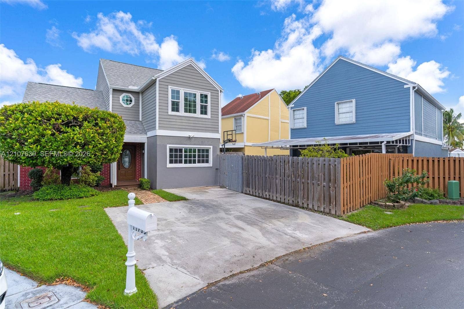 11735 SW 114th Terrace, #11735, Miami, Miami, FL 33186 Two-story residence featuring horizontal lap siding, multi-pane windows, an oval glass-panel front door, and a concrete driveway