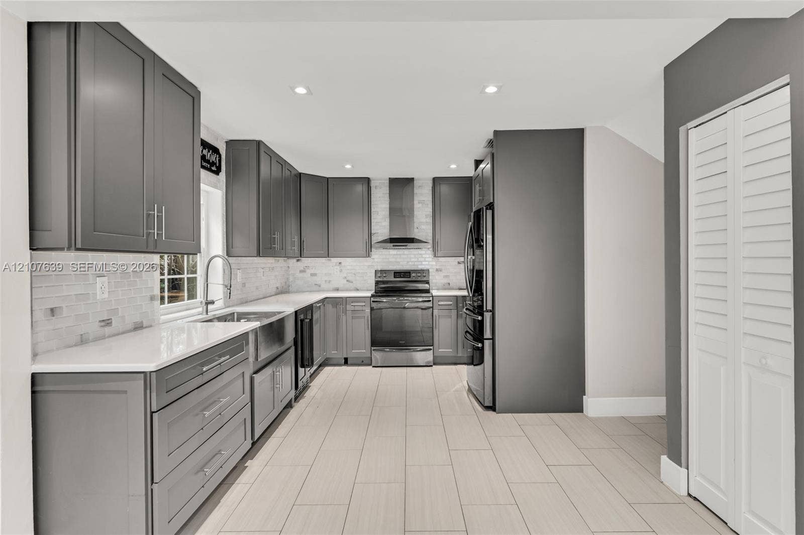 11735 SW 114th Terrace, #11735, Miami, Miami, FL 33186 Kitchen featuring dark grey shaker-style cabinetry, quartz countertops, white subway tile backsplash, stainless steel appliances, and rectified tile flooring