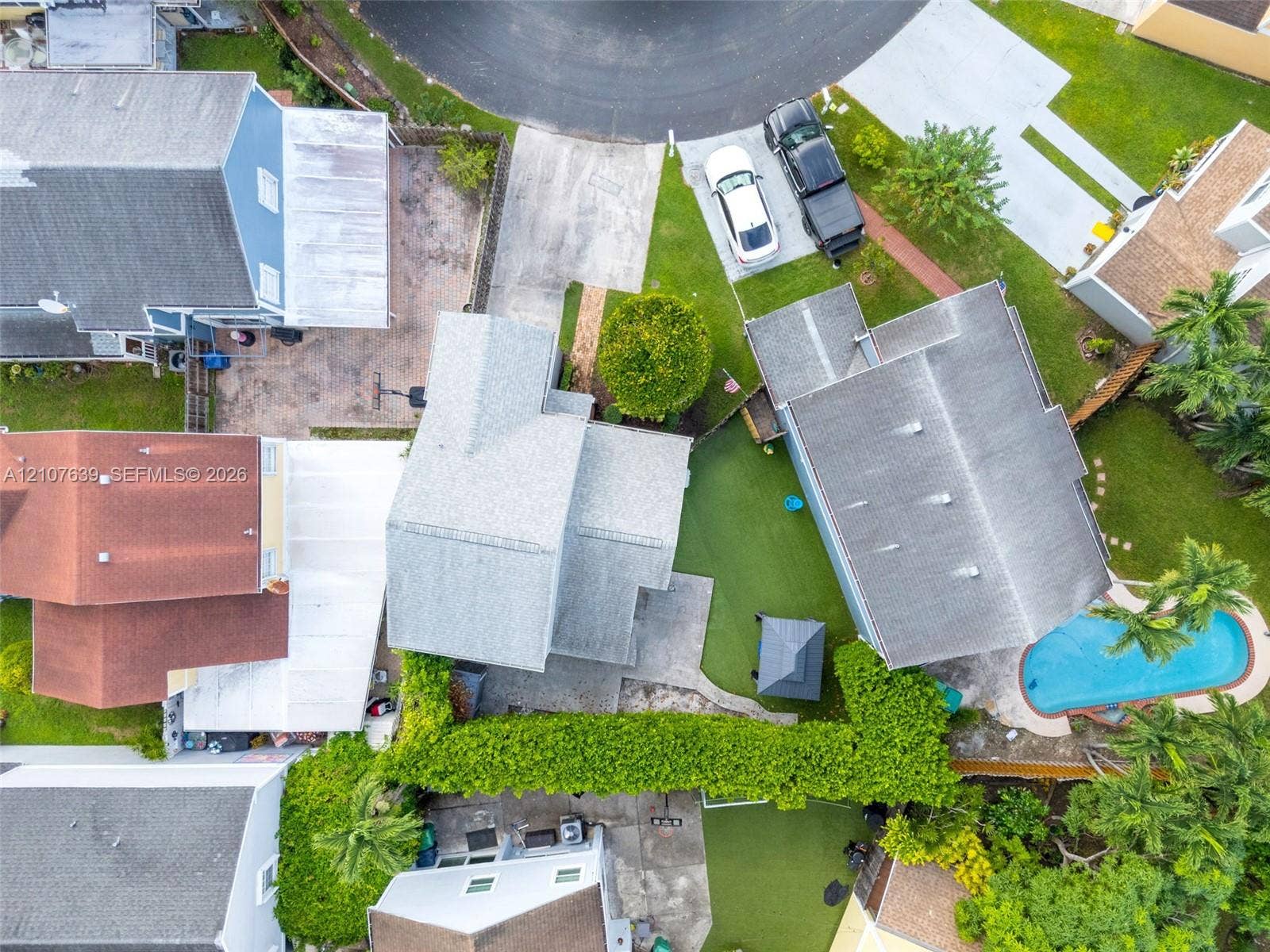 11735 SW 114th Terrace, #11735, Miami, Miami, FL 33186 Aerial perspective of property featuring a private swimming pool, concrete patio, artificial turf lawn, and mature perimeter landscaping