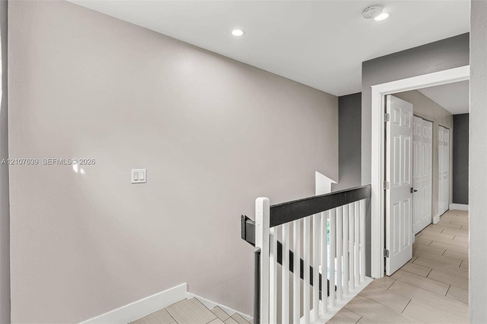 11735 SW 114th Terrace, #11735, Miami, Miami, FL 33186 Staircase featuring a high-contrast railing with white balusters and a dark handrail, neutral wall tones, recessed lighting, and tile flooring