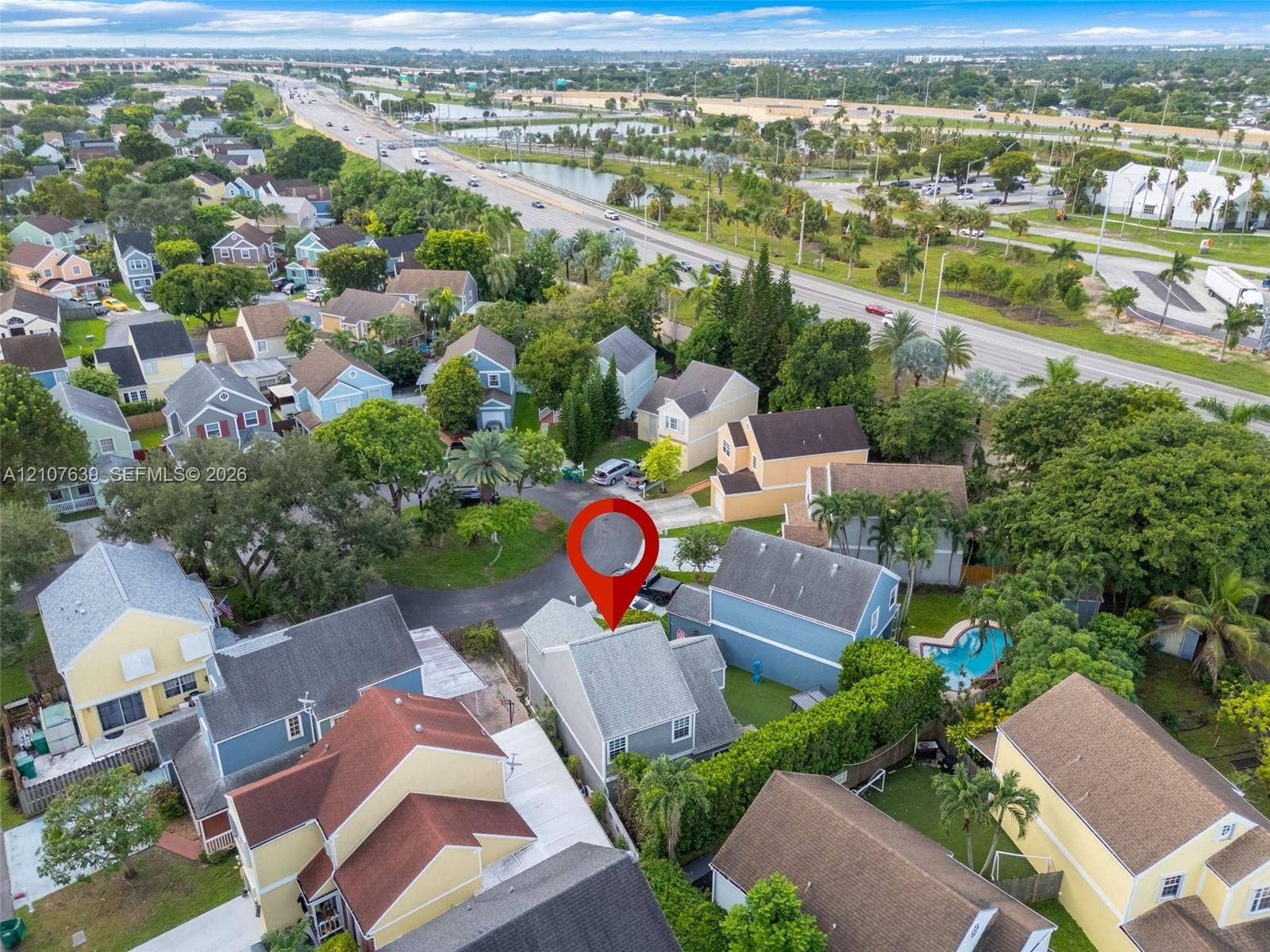 11735 SW 114th Terrace, #11735, Miami, Miami, FL 33186 Aerial perspective of a multi-story residence featuring a shingled roof, asphalt driveway, and private swimming pool within a residential neighborhood