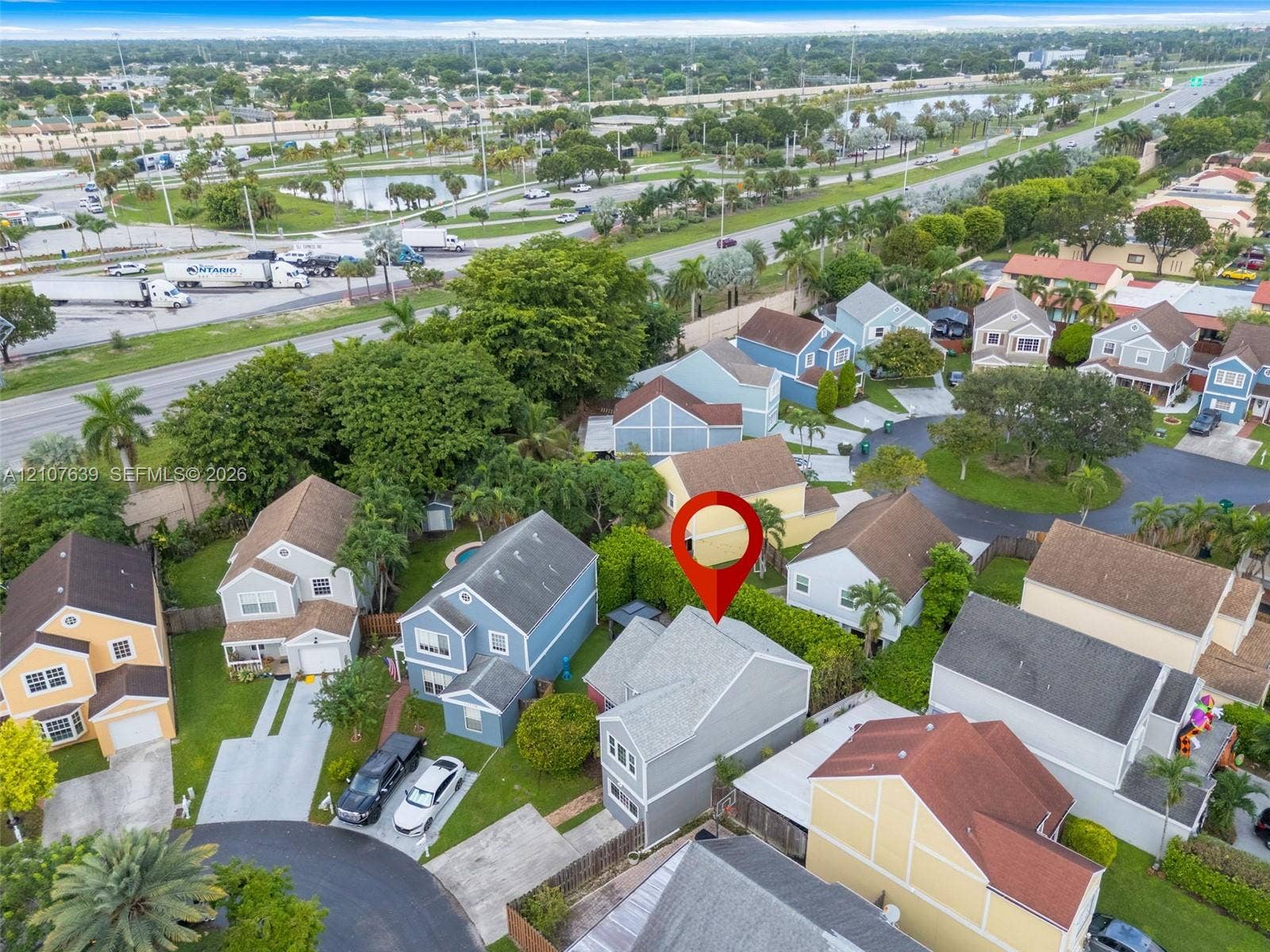11735 SW 114th Terrace, #11735, Miami, Miami, FL 33186 Two-story residence featuring light gray siding, a pitched shingled roof, a private driveway, and a fenced backyard