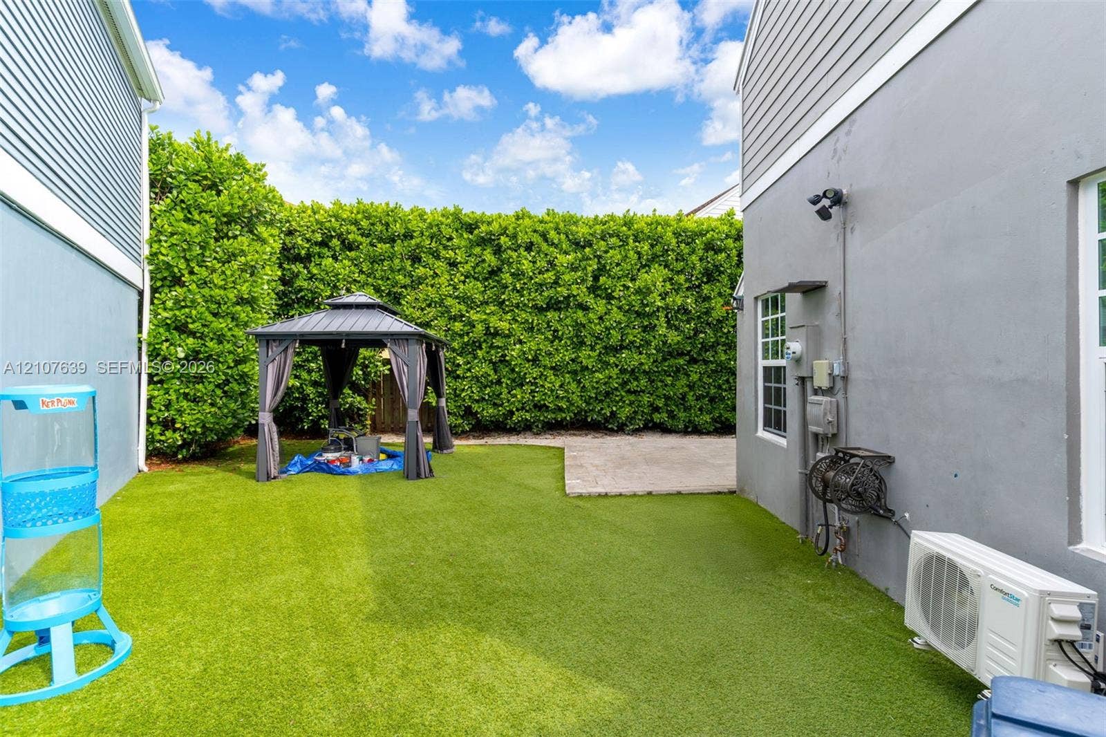 11735 SW 114th Terrace, #11735, Miami, Miami, FL 33186 Private backyard featuring artificial turf, a paved patio area, and dense perimeter hedging