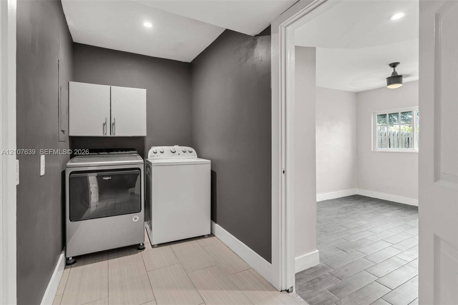 11735 SW 114th Terrace, #11735, Miami, Miami, FL 33186 Laundry area featuring neutral-toned tile flooring, charcoal-painted walls, and white upper cabinetry