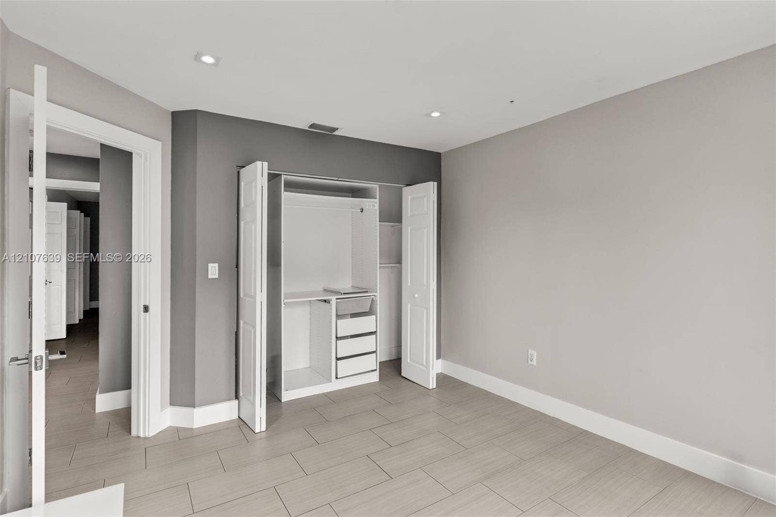 11735 SW 114th Terrace, #11735, Miami, Miami, FL 33186 Room featuring large-format tile flooring, recessed lighting, and a built-in closet system with integrated shelving and drawers