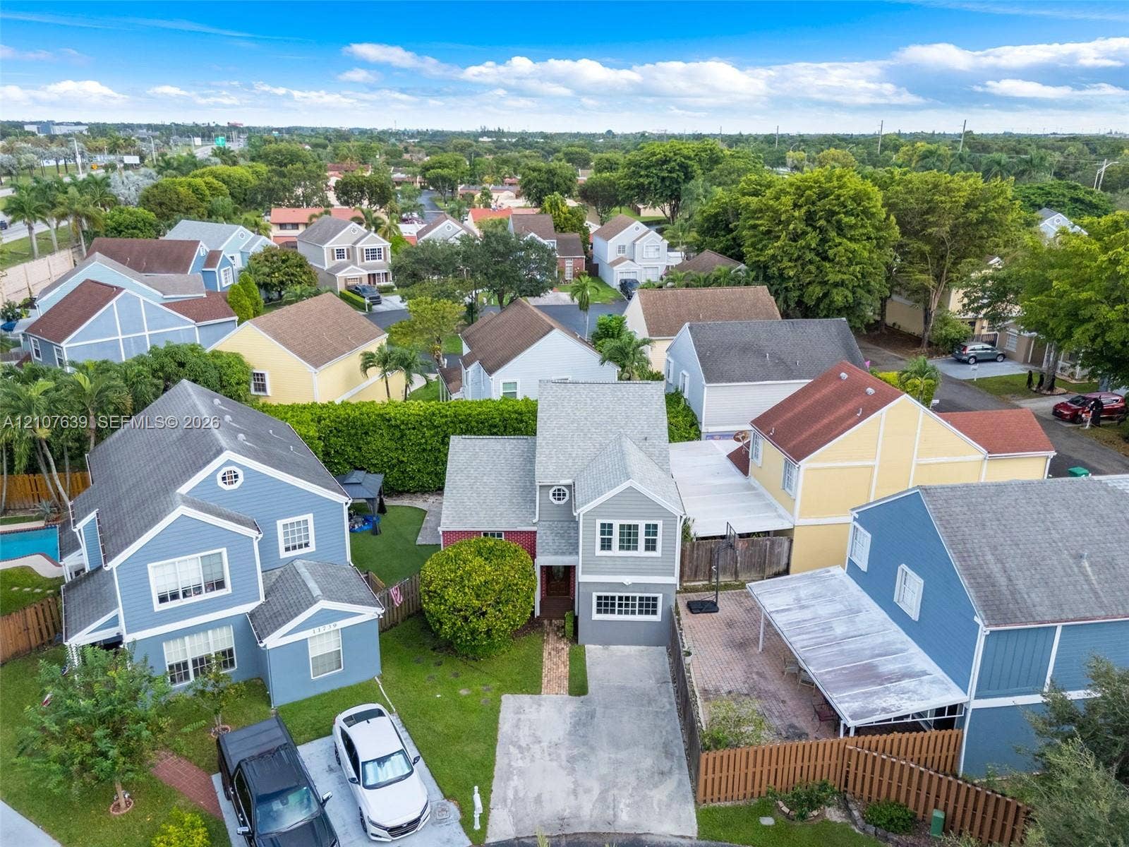 11735 SW 114th Terrace, #11735, Miami, Miami, FL 33186 Two-story residence featuring a concrete driveway, multi-gabled roofline, lap siding, a front entryway with a glass-paneled door, and a paved brick walkway
