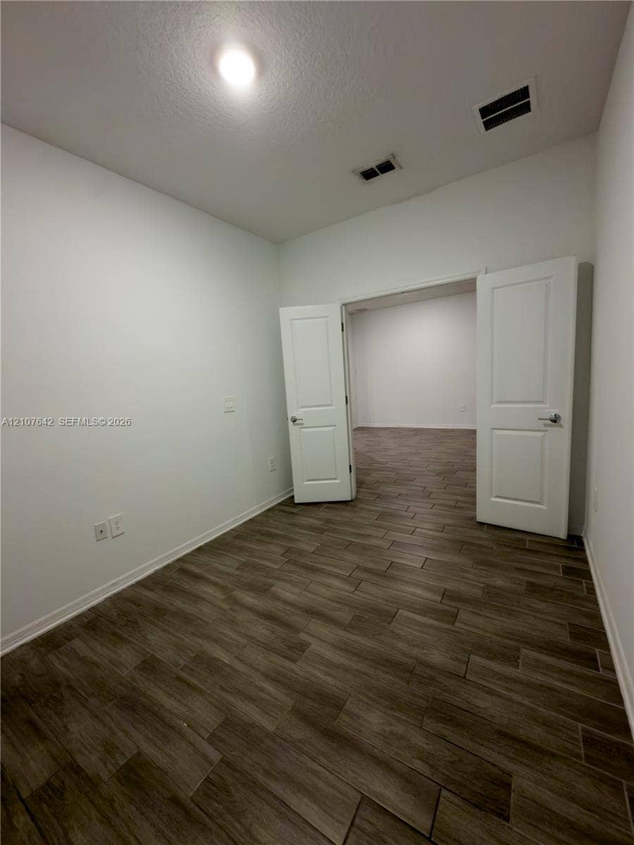 664 Tanaro Lane, Haines City, FL 33844 Interior space featuring wood-finish tile flooring and white panel double doors with metallic hardware