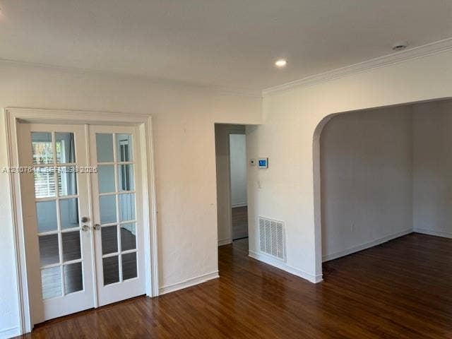 7550 SW 67th Avenue, South Miami, South Miami, FL 33143 Interior space featuring wood-finish flooring, white French doors with glass panes, an arched architectural opening, and recessed ceiling lighting