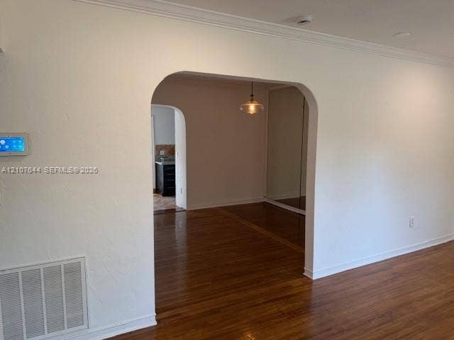 7550 SW 67th Avenue, South Miami, South Miami, FL 33143 Arched doorways, wood-finish flooring, crown molding, a hanging pendant light fixture, and mirrored sliding closet doors