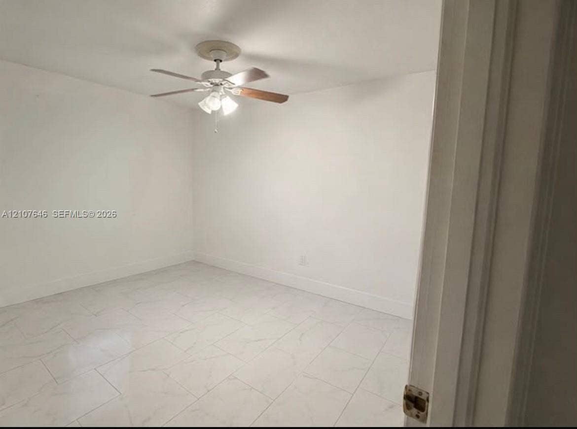 75 NW 116th Street, Miami, FL 33168 Interior room featuring white-toned tile flooring with marble-style veining and a ceiling fan with integrated multi-bulb light fixture