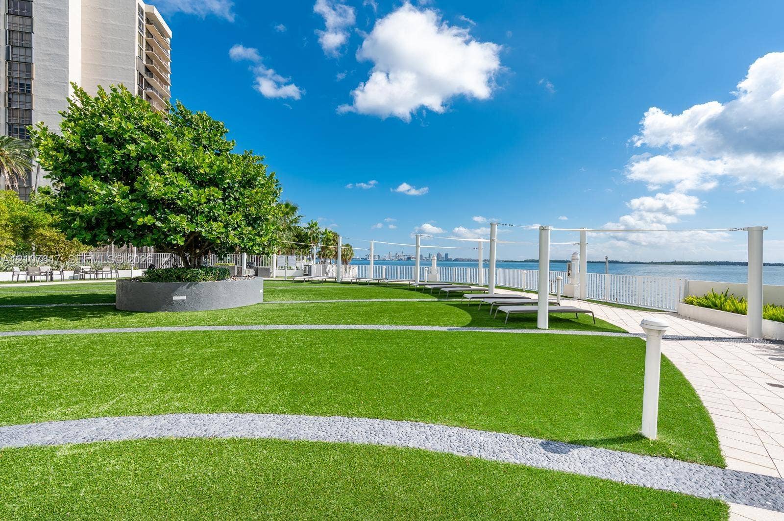 200 SE 15th Road, #PH-A, Miami, Miami, FL 33129 Waterfront recreational area featuring manicured green space, circular concrete planter, integrated stone pathways, and white perimeter railing