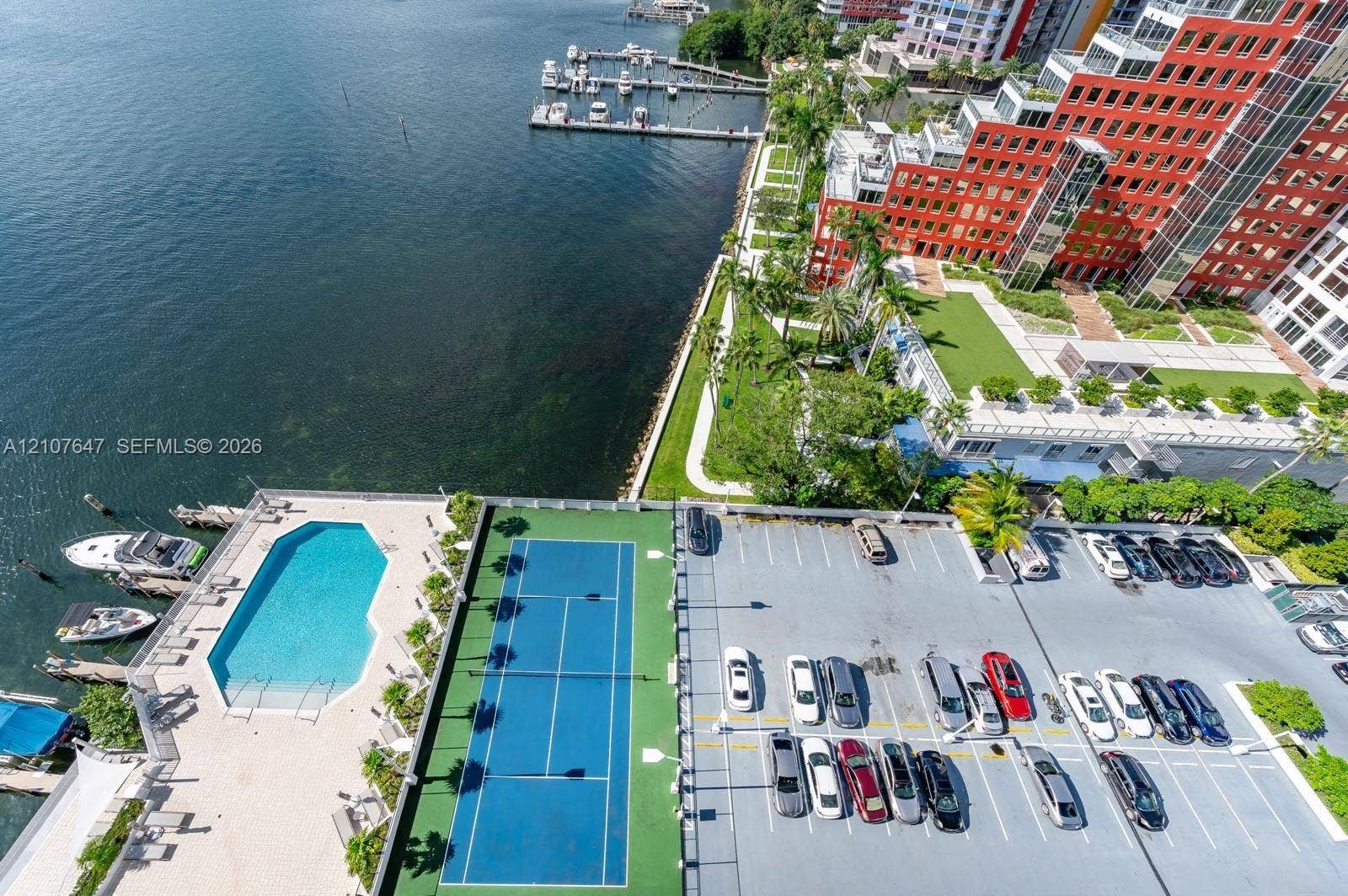 200 SE 15th Road, #PH-A, Miami, Miami, FL 33129 Aerial perspective of property amenities including a waterfront swimming pool, a hard-surface tennis court, and dedicated on-site parking