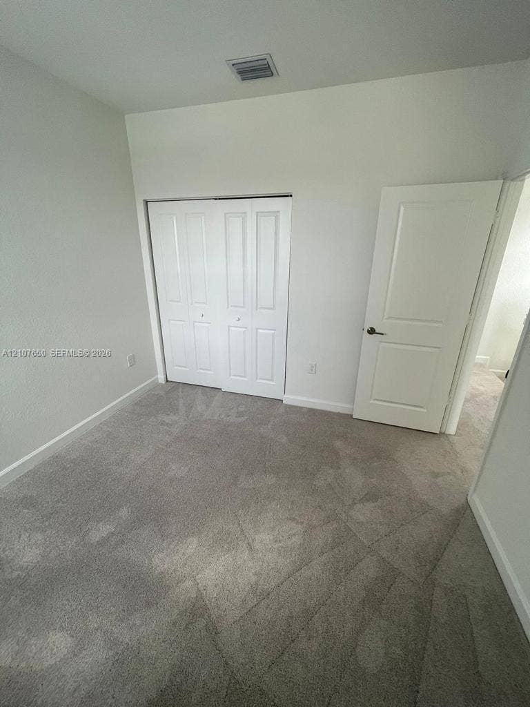 1787 SE 26th Terrace, Homestead, Homestead, FL 33035 Neutral-toned carpeting, white two-panel interior door, and a built-in sliding closet with white paneled doors