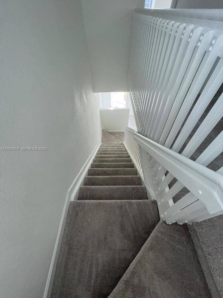1787 SE 26th Terrace, Homestead, Homestead, FL 33035 Staircase featuring wall-to-wall carpeting and a white vertical balustrade railing