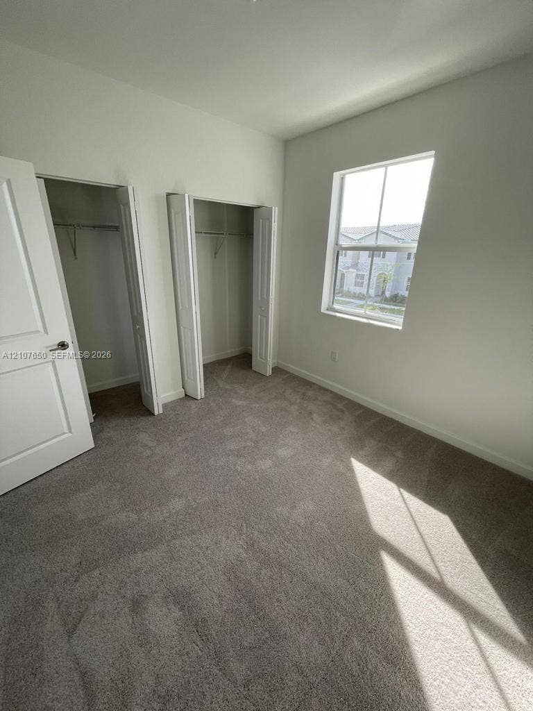 1787 SE 26th Terrace, Homestead, Homestead, FL 33035 Neutral wall palette, carpeting, dual-door closets with shelving, and window providing natural light