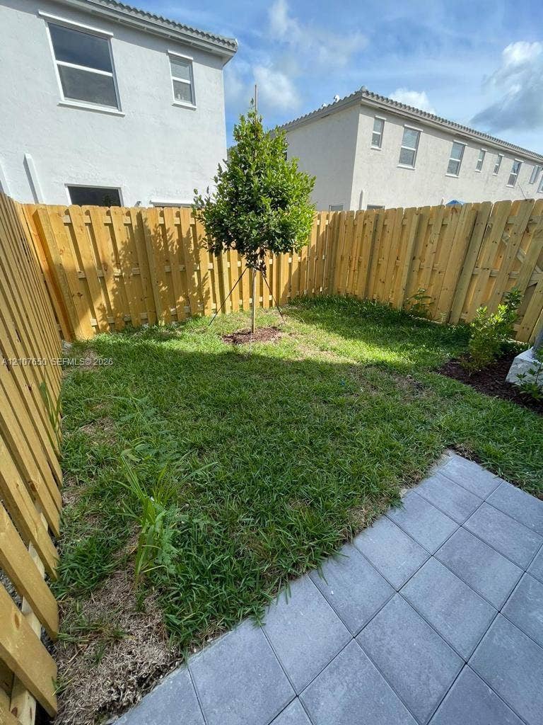 1787 SE 26th Terrace, Homestead, Homestead, FL 33035 Enclosed outdoor area featuring a wood privacy fence, paved patio, and grass lawn