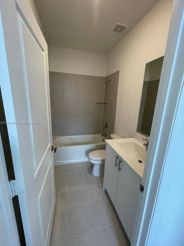 1787 SE 26th Terrace, Homestead, Homestead, FL 33035 Bathroom featuring a vanity with a solid-surface countertop, tile flooring, and a tub-shower combination with full-height wall tile surrounds