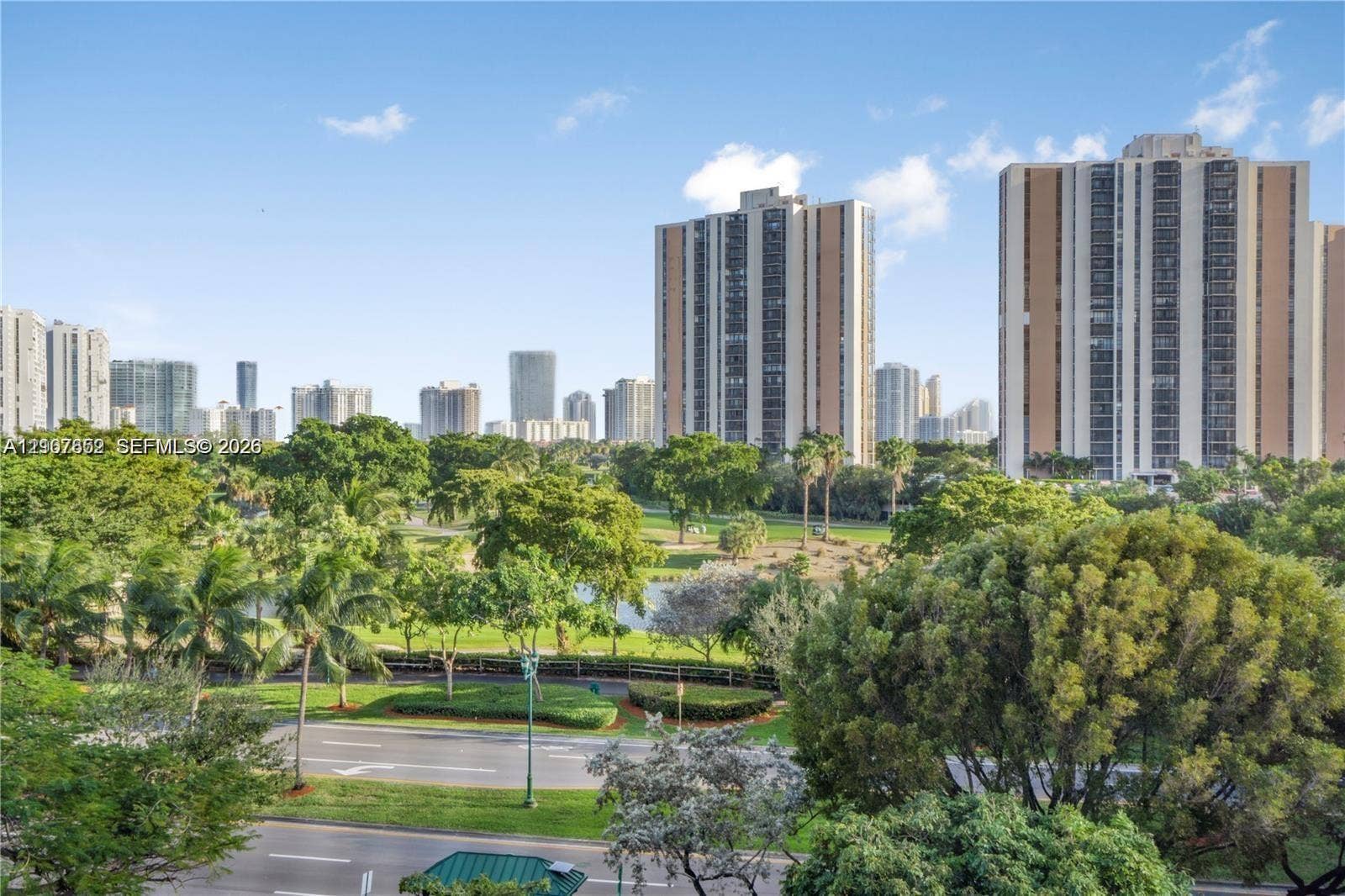 20500 W Country Club Drive, #607, Aventura, Aventura, FL 33180 Panoramic perspective featuring expansive green spaces, mature trees, a central body of water, and an urban skyline