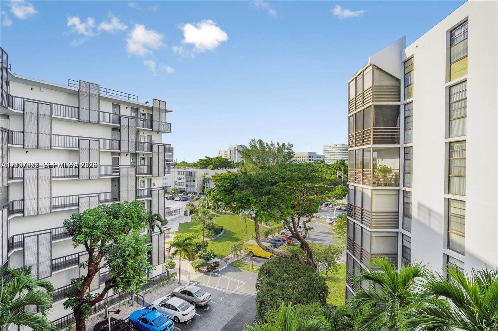 20500 W Country Club Drive, #607, Aventura, Aventura, FL 33180 Multi-story residential complex featuring white stucco facades, grid-patterned exterior metal screening, glass-enclosed balconies, and landscaped grounds with mature trees