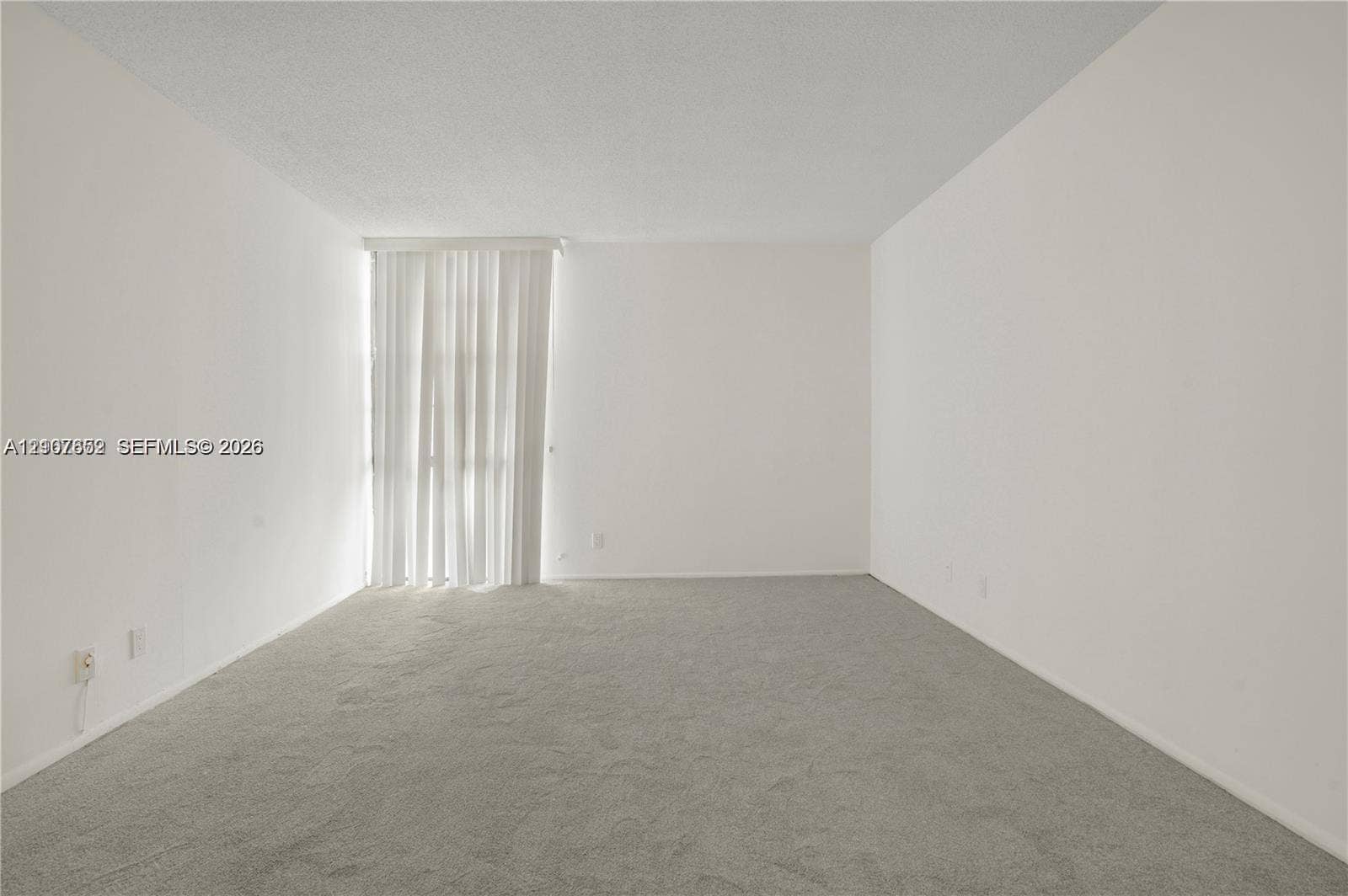 20500 W Country Club Drive, #607, Aventura, Aventura, FL 33180 Neutral-toned interior space featuring wall-to-wall carpeting and floor-to-ceiling vertical blinds