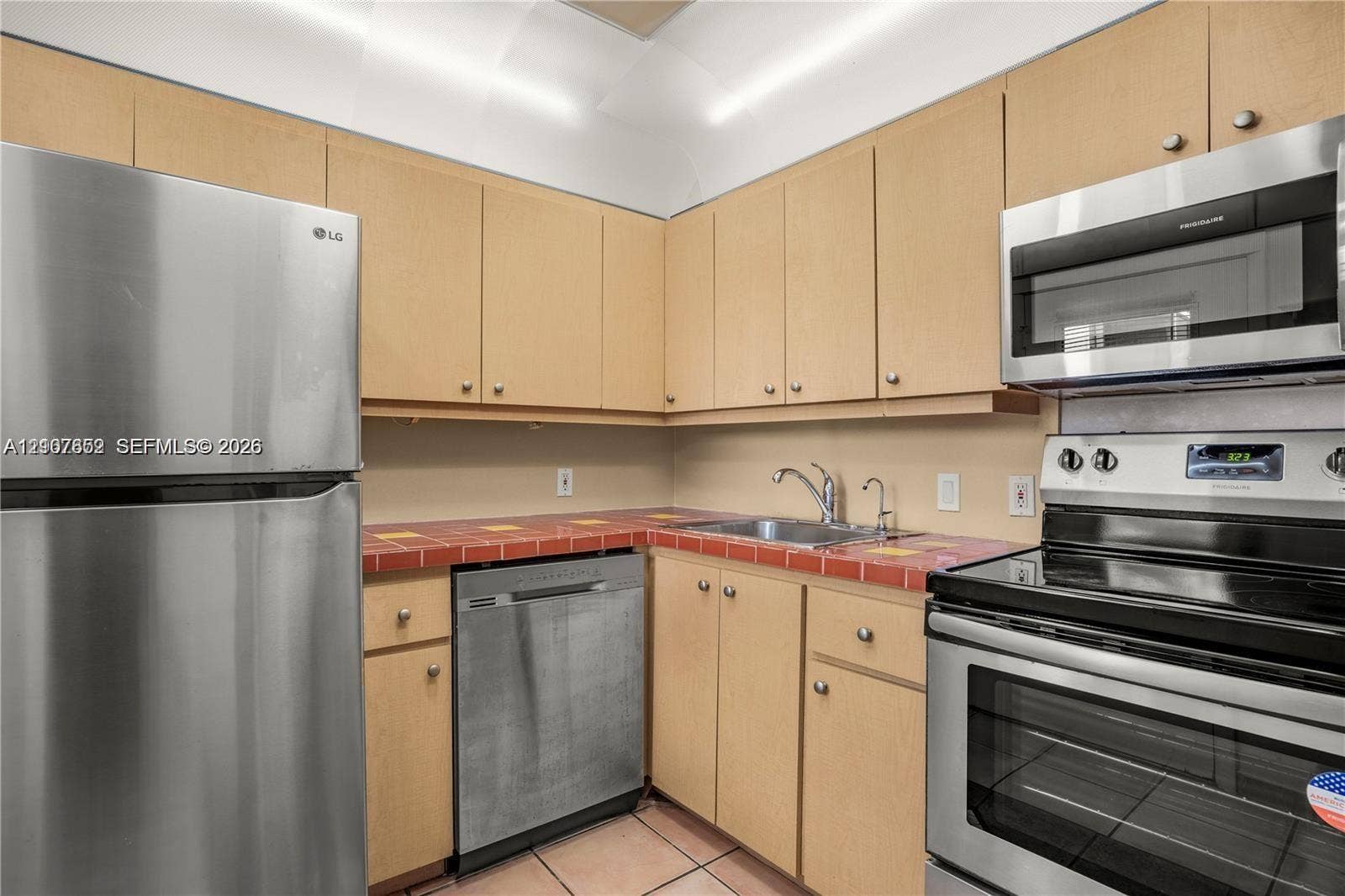 20500 W Country Club Drive, #607, Aventura, Aventura, FL 33180 Kitchen featuring light-tone wood cabinetry, tiled countertops, stainless steel appliances, and tile flooring