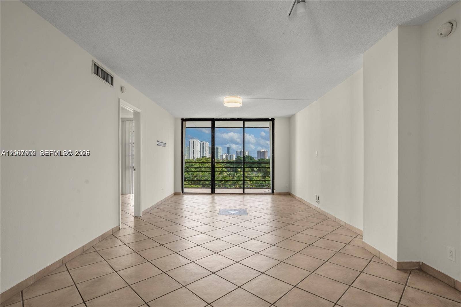 20500 W Country Club Drive, #607, Aventura, Aventura, FL 33180 Open floor plan featuring diagonal-set tile flooring, flush-mount ceiling lighting, and large sliding glass doors with a black frame