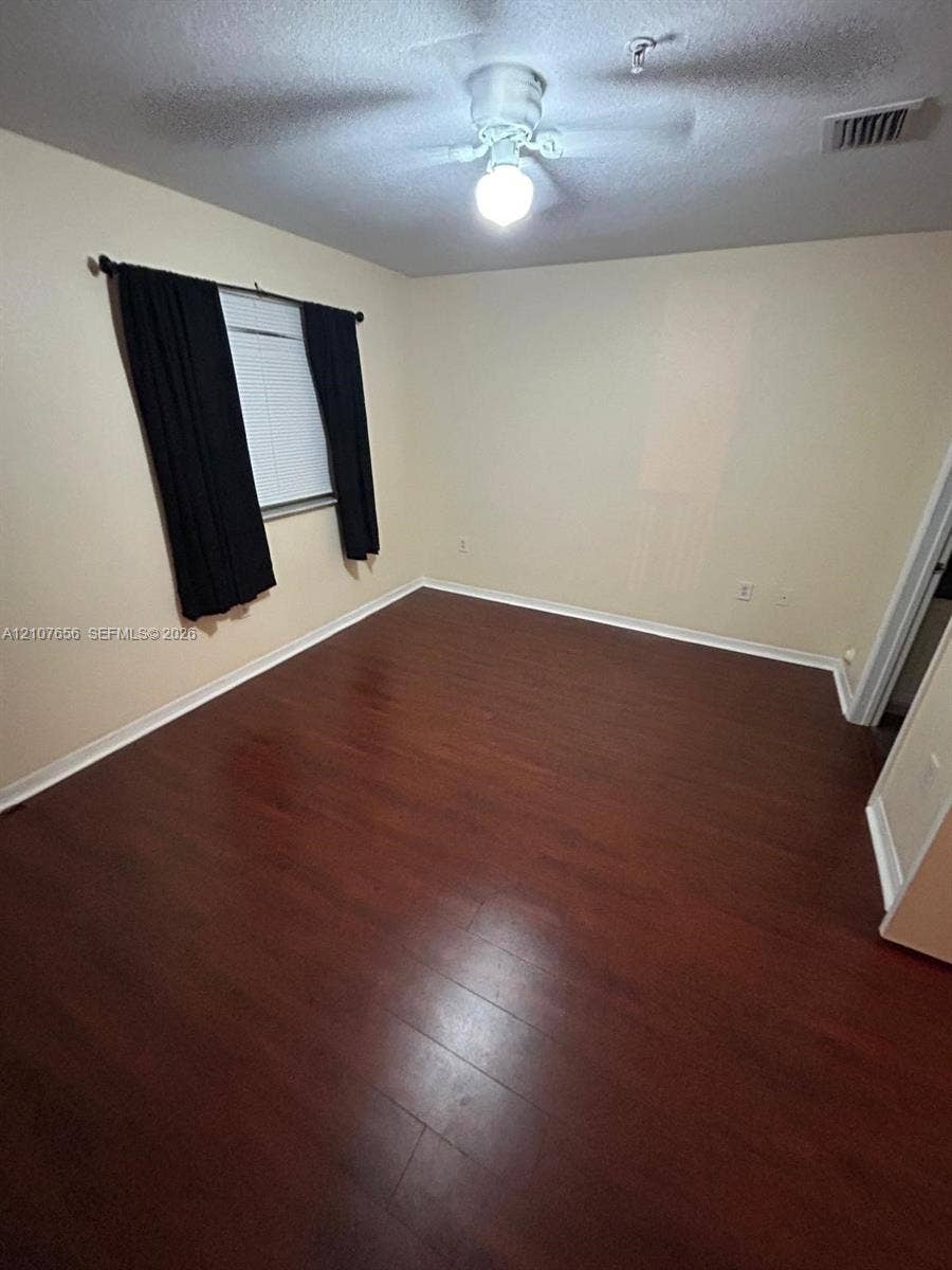 2088 NE 167th Street, #2-111, North Miami Beach, North Miami Beach, FL 33162 Room featuring wood-finish flooring, a ceiling fan with integrated lighting, and a single-pane window with horizontal blinds