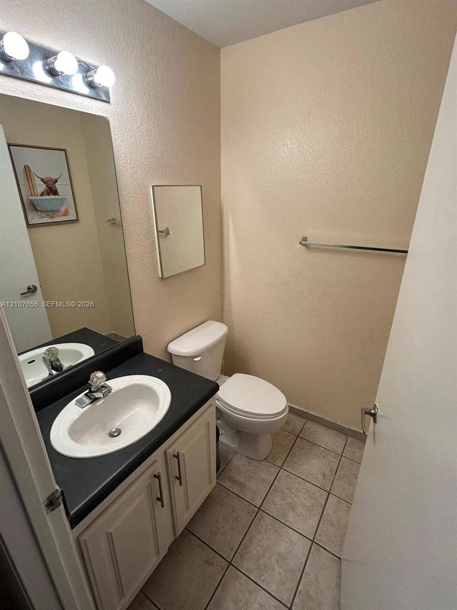 2088 NE 167th Street, #2-111, North Miami Beach, North Miami Beach, FL 33162 Bathroom featuring a vanity with dark countertop, integrated oval sink, ceramic tile flooring, and a multi-bulb vanity light fixture