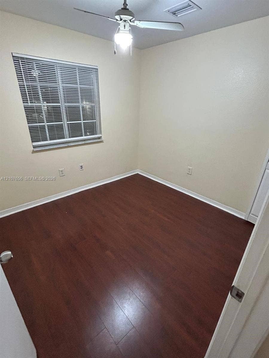 2088 NE 167th Street, #2-111, North Miami Beach, North Miami Beach, FL 33162 Interior room featuring wood-finish flooring, a ceiling fan with integrated light fixture, and a window with horizontal blinds