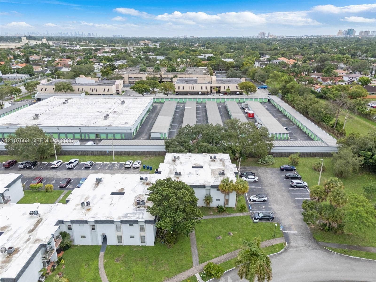 7245 SW 94th Place, #K4, Miami, FL 33173 Aerial view of commercial property featuring paved parking areas, multi-unit flat-roof structures, and maintained landscape surroundings