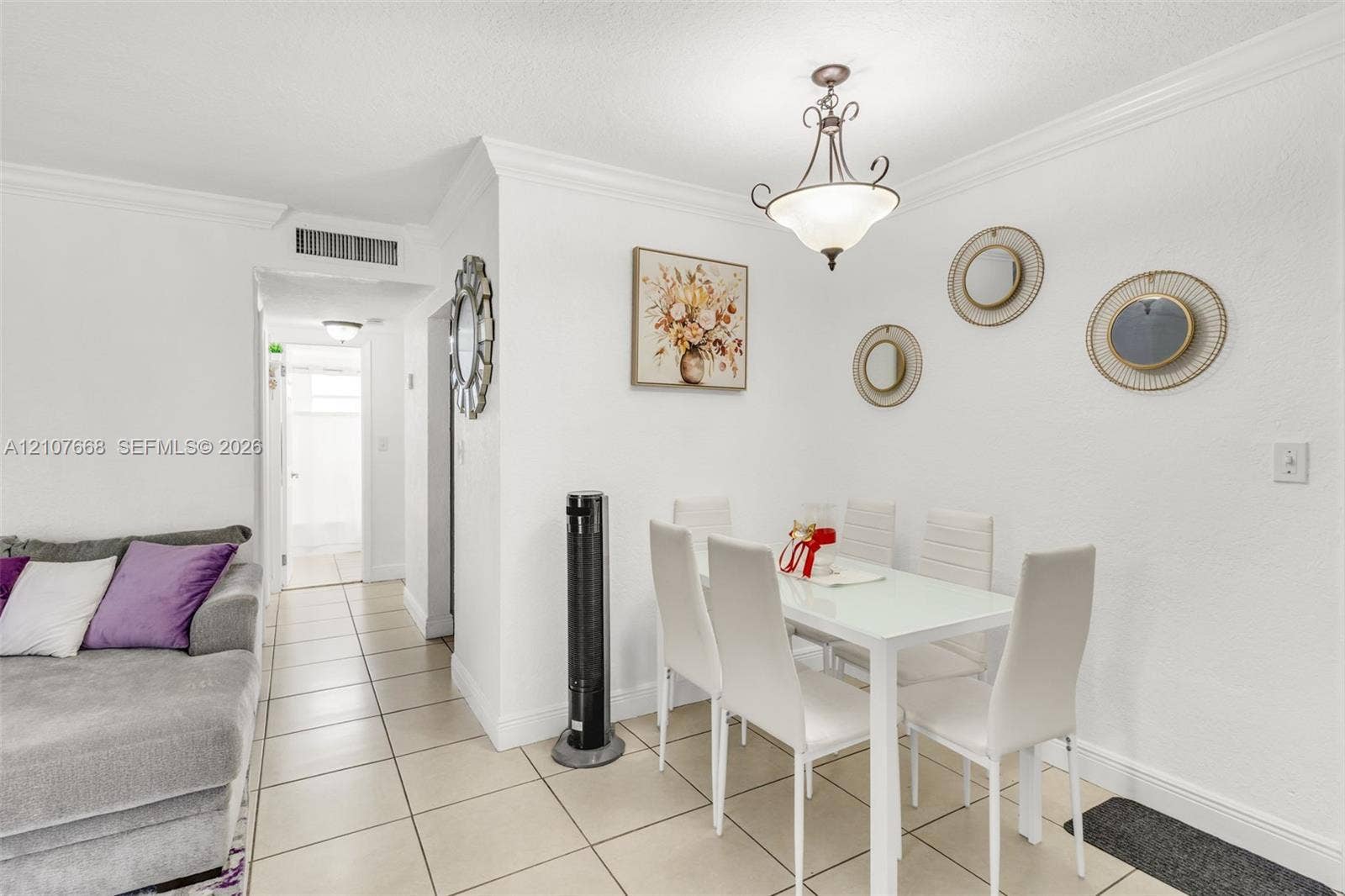 7245 SW 94th Place, #K4, Miami, FL 33173 Neutral-toned tile flooring, crown molding, and a suspended multi-light fixture