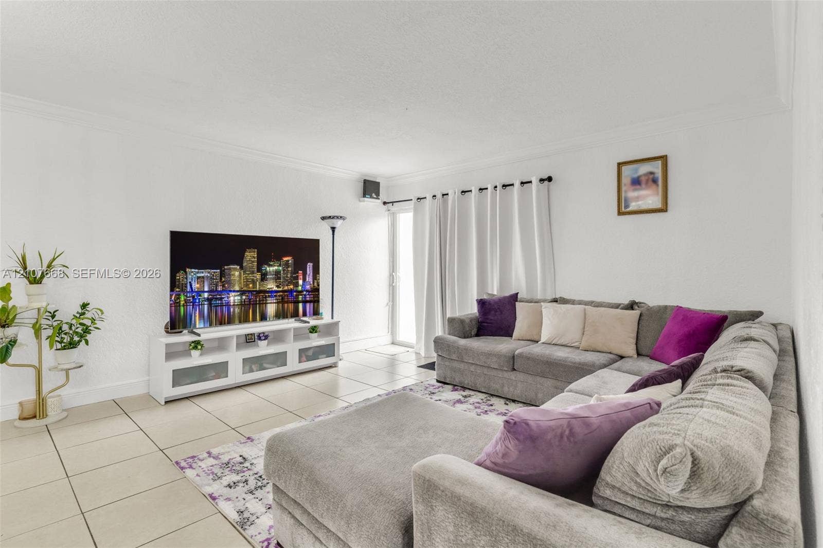 7245 SW 94th Place, #K4, Miami, FL 33173 Living area featuring neutral tile flooring, crown molding, and a sliding glass door