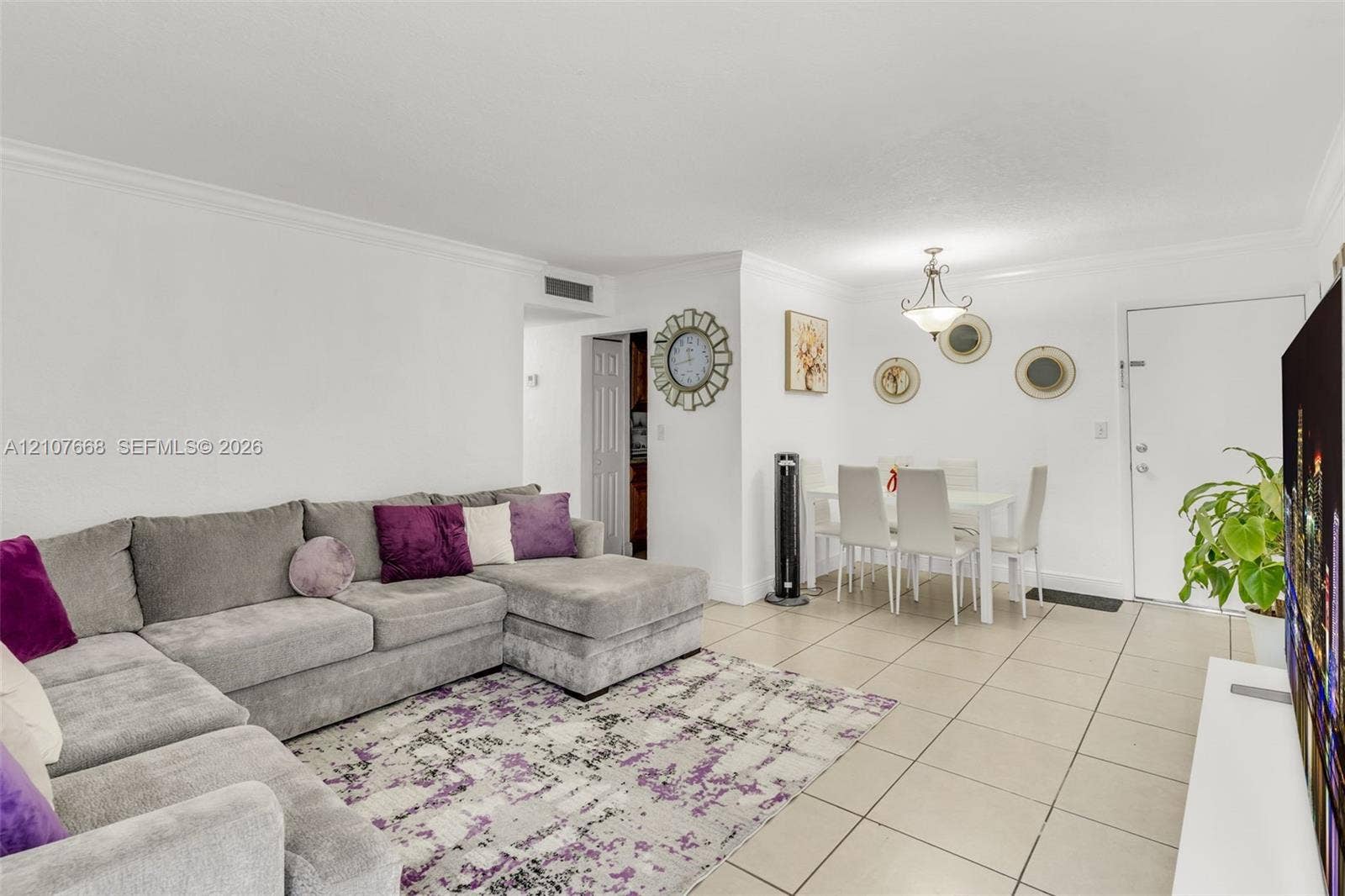 7245 SW 94th Place, #K4, Miami, FL 33173 Neutral-toned ceramic tile flooring, crown molding, and a suspended multi-light chandelier