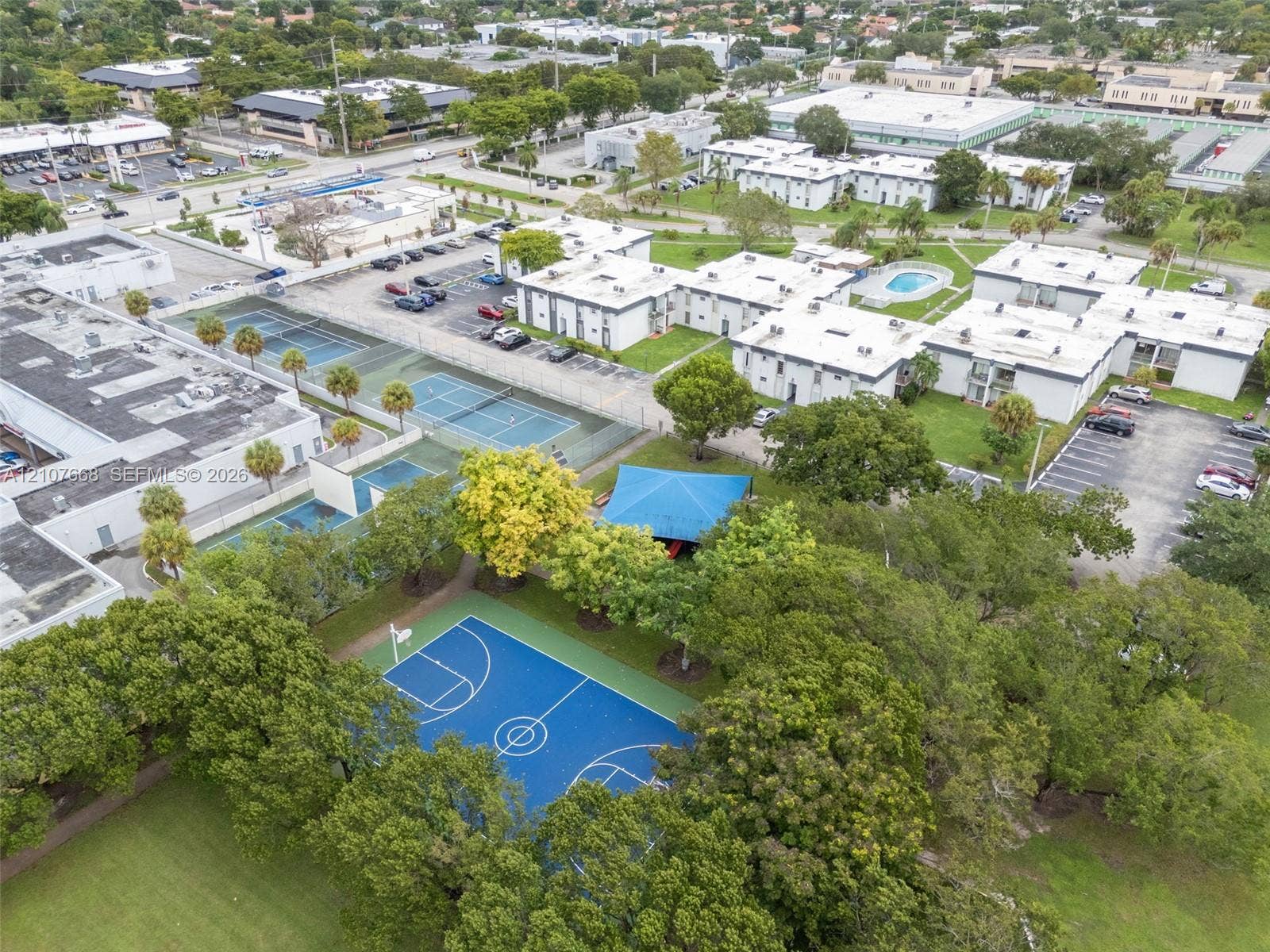 7245 SW 94th Place, #K4, Miami, FL 33173 Aerial perspective featuring a basketball court, multiple tennis courts, an outdoor swimming pool, and a shaded pavilion