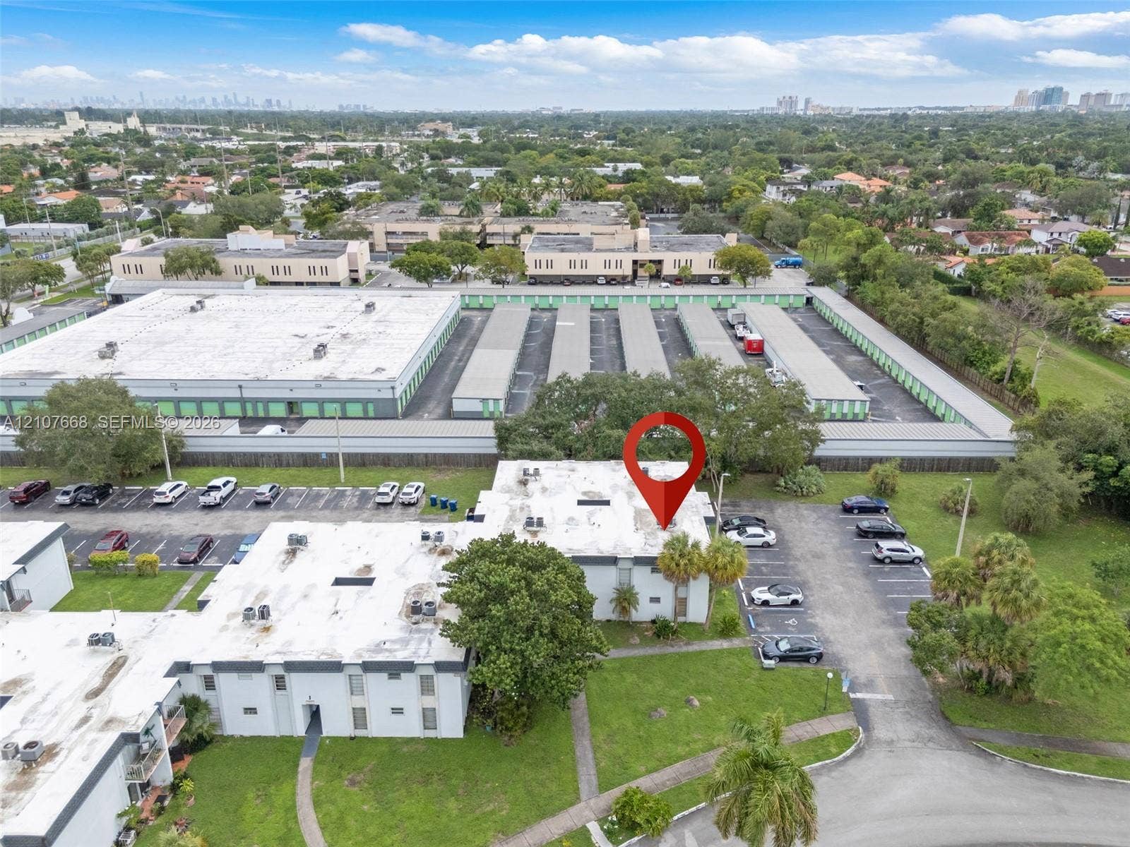 7245 SW 94th Place, #K4, Miami, FL 33173 Aerial perspective of multi-level building with white exterior walls, flat roof system, dedicated surface parking, and manicured landscaping