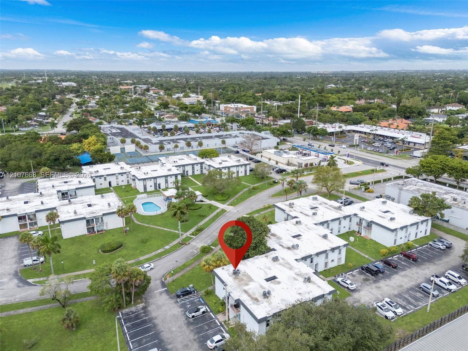 7245 SW 94th Place, #K4, Miami, FL 33173 Aerial perspective of multi-family complex featuring paved parking areas, sprawling grass lawns, and an outdoor swimming pool