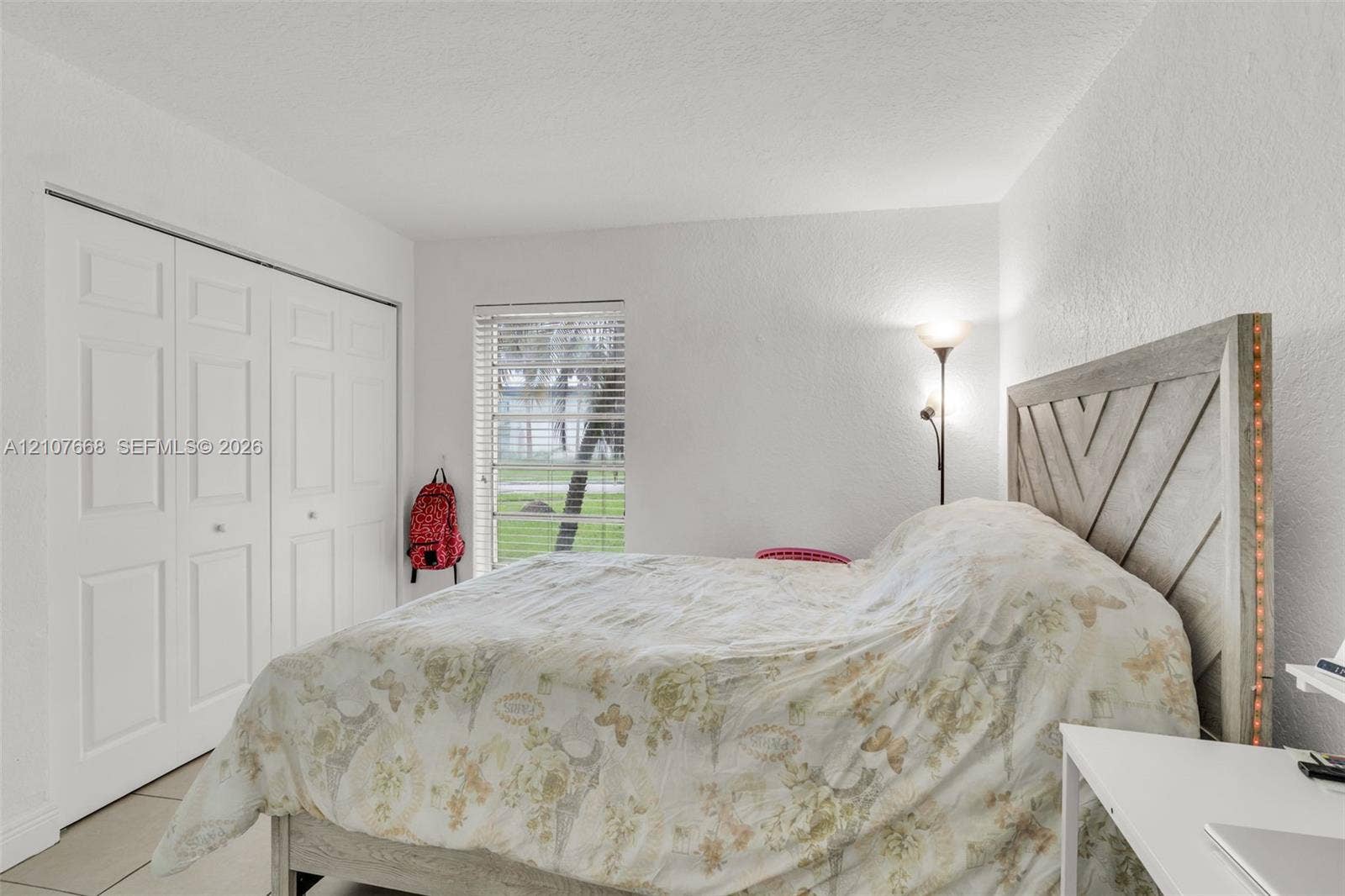 7245 SW 94th Place, #K4, Miami, FL 33173 Room featuring white walls, large multi-panel closet doors, and a rectangular window with horizontal blinds