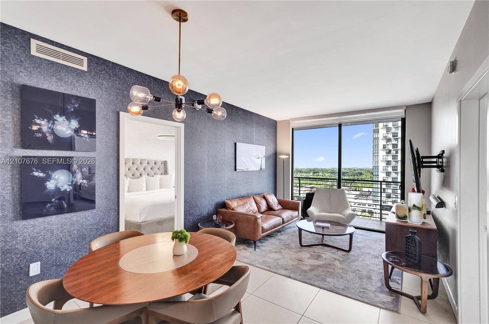 5350 NW 84th Avenue, #1004, Doral, FL 33166 Floor-to-ceiling windows, textured accent wall, multi-light modern chandelier, and tile flooring