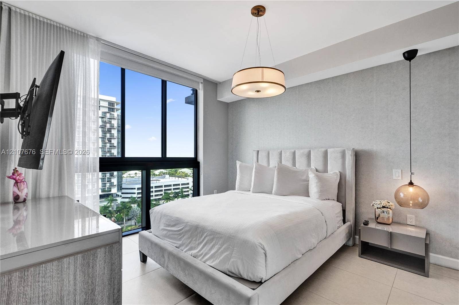 5350 NW 84th Avenue, #1004, Doral, FL 33166 Floor-to-ceiling windows, neutral tile flooring, drum-style chandelier, pendant lighting, and textured wall finish