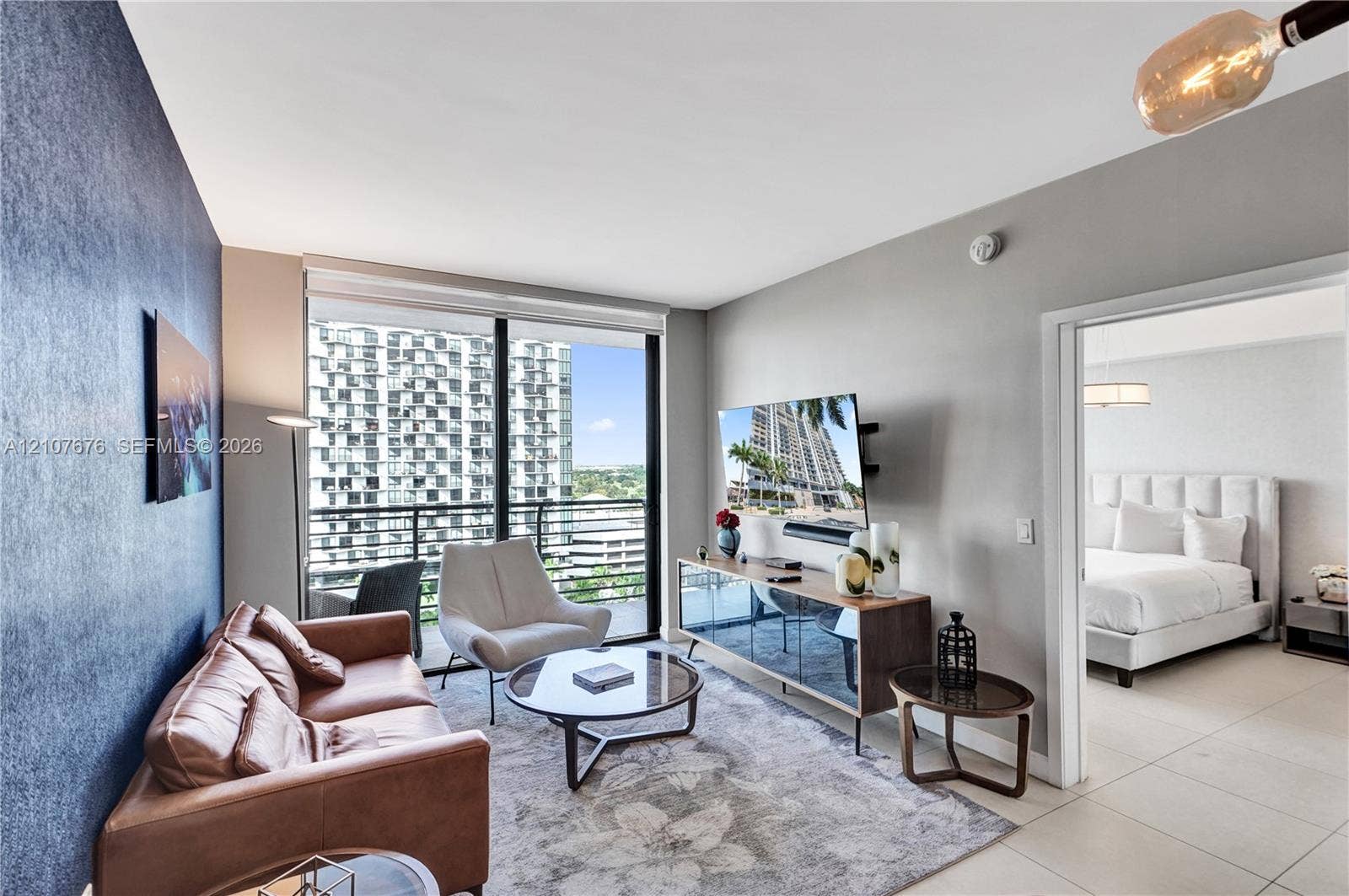 5350 NW 84th Avenue, #1004, Doral, FL 33166 Floor-to-ceiling windows with balcony access, ceramic tile flooring, and accent wall