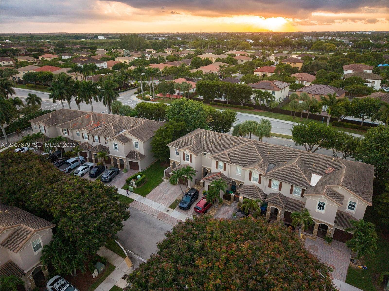 22066 SW 93rd Place, Cutler Bay, FL 33190 Aerial perspective of a multi-unit residential community featuring paver driveways, pitched shingle roofing, and established landscaping