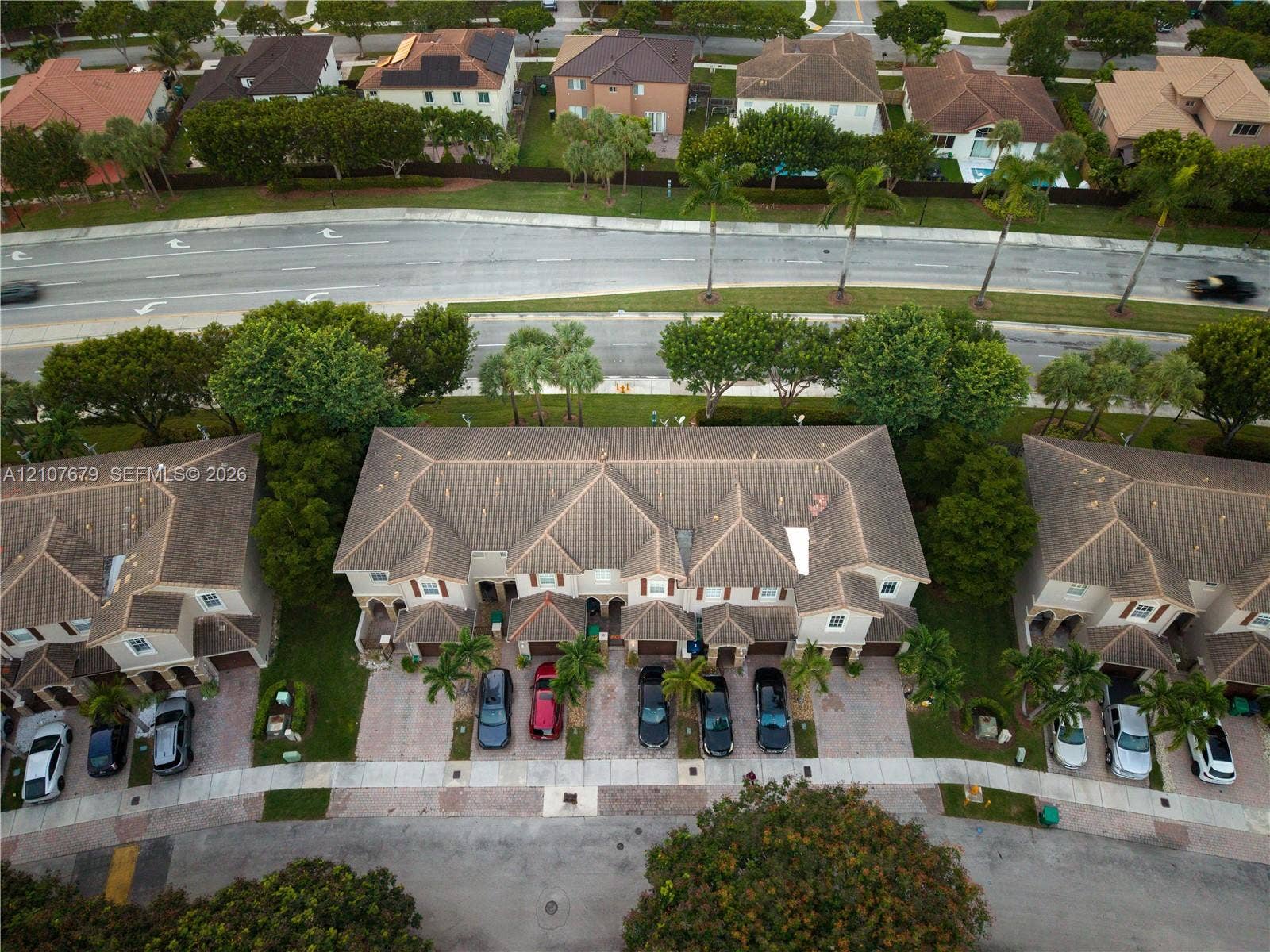 22066 SW 93rd Place, Cutler Bay, FL 33190 Aerial view of multi-unit residential property featuring a multi-pitched tile roof, paver driveways, and mature landscaping