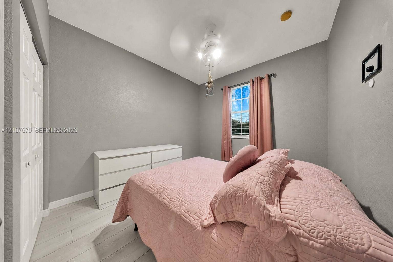 22066 SW 93rd Place, Cutler Bay, FL 33190 Neutral-toned room featuring tile flooring, bi-fold closet doors, a central ceiling fan with integrated lighting, and a single-pane window