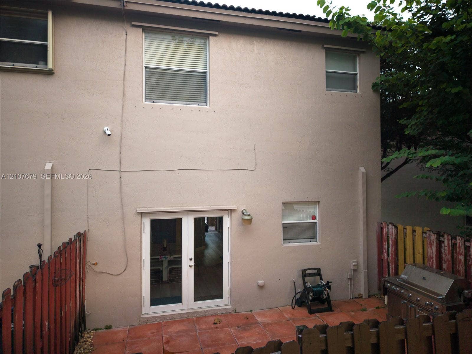 22066 SW 93rd Place, Cutler Bay, FL 33190 Stucco exterior featuring French doors, a tiled patio, and wood fencing
