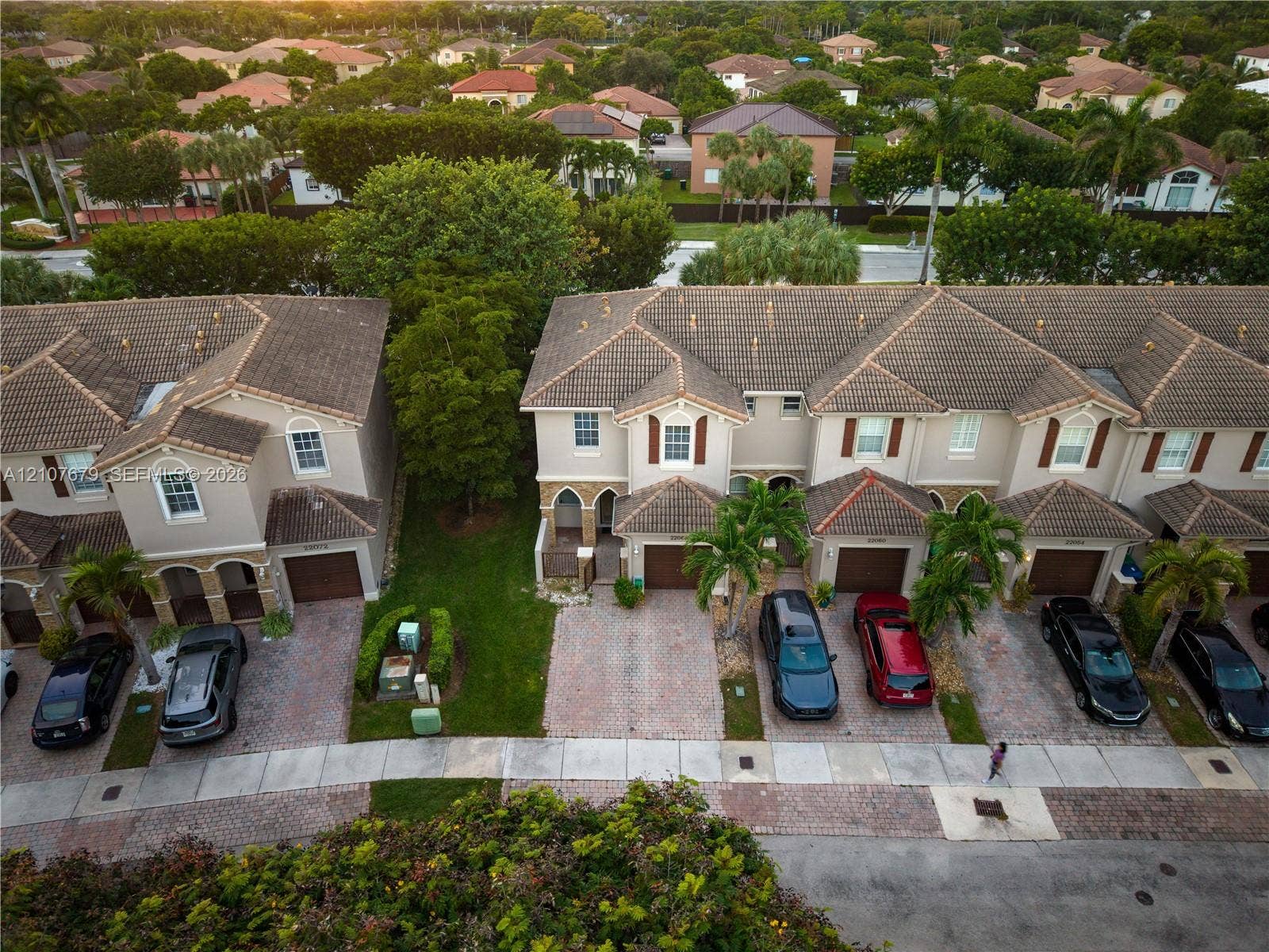 22066 SW 93rd Place, Cutler Bay, FL 33190 Aerial perspective of multi-family residences featuring clay tile roofing, paved driveways, arched architectural detailing, and integrated garage spaces